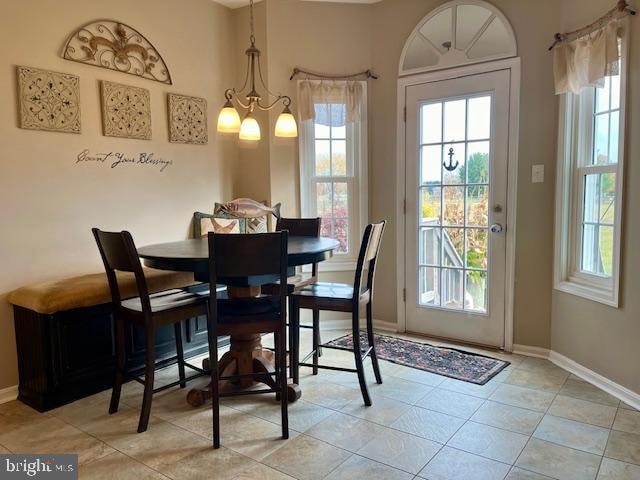 dining space with a chandelier and light tile patterned flooring