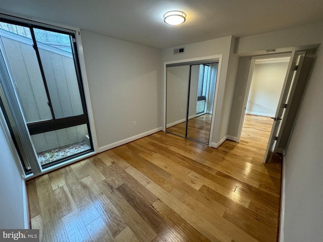 unfurnished bedroom featuring light hardwood / wood-style flooring and a closet