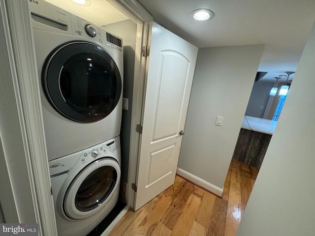 washroom with light wood-type flooring and stacked washer / dryer