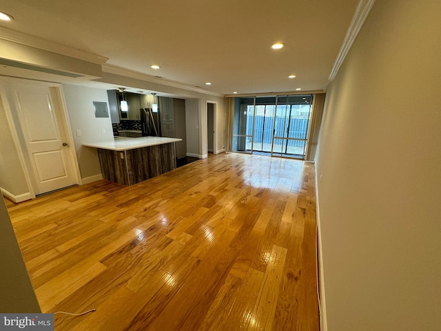 unfurnished living room featuring light hardwood / wood-style floors, expansive windows, and crown molding