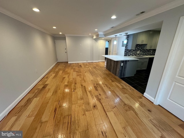 kitchen with light wood-type flooring, backsplash, crown molding, and sink