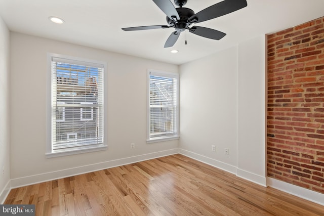 empty room with ceiling fan and light hardwood / wood-style floors