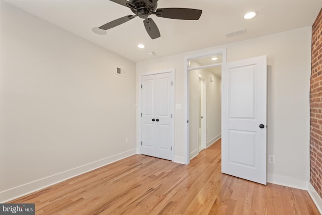 unfurnished bedroom featuring a closet, light hardwood / wood-style floors, and ceiling fan