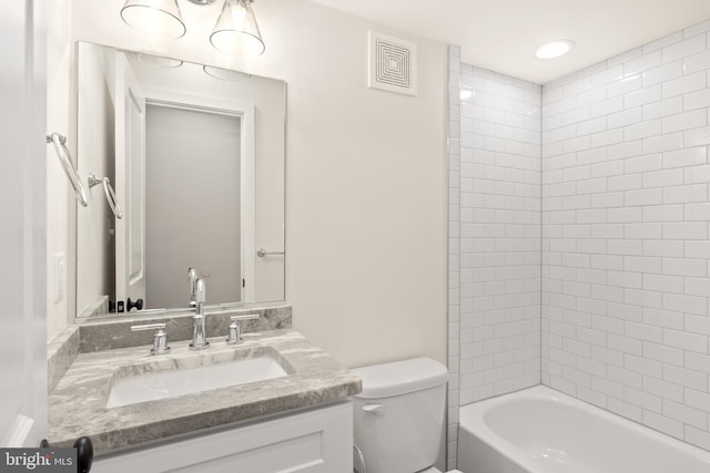 full bathroom featuring toilet, tiled shower / bath, and vanity