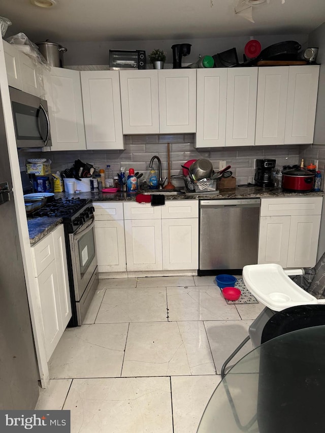 kitchen with white cabinets, decorative backsplash, sink, and appliances with stainless steel finishes