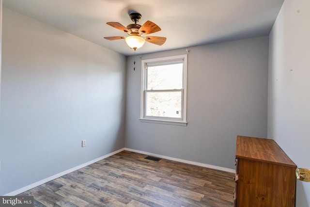 unfurnished room with ceiling fan and dark hardwood / wood-style floors