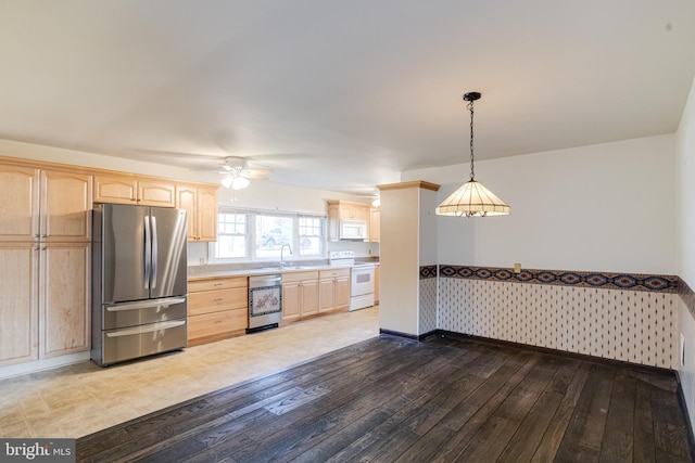 kitchen featuring light brown cabinetry, white appliances, decorative light fixtures, and light hardwood / wood-style floors