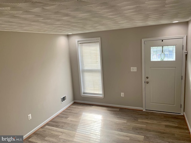 foyer featuring light hardwood / wood-style floors, plenty of natural light, and a textured ceiling