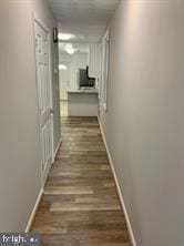 hallway with dark hardwood / wood-style flooring