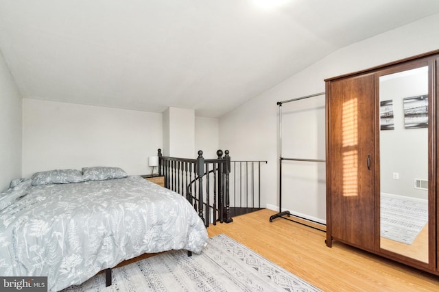 bedroom featuring lofted ceiling and hardwood / wood-style flooring