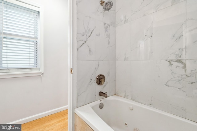 bathroom with tiled shower / bath and wood-type flooring