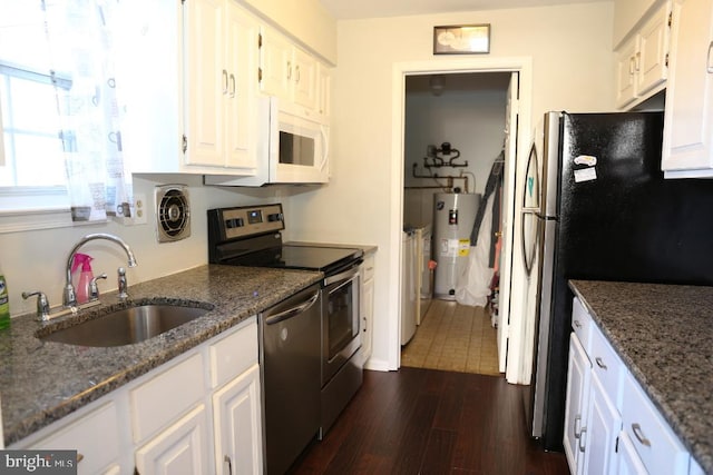 kitchen with electric water heater, sink, dark hardwood / wood-style floors, white cabinetry, and stainless steel appliances