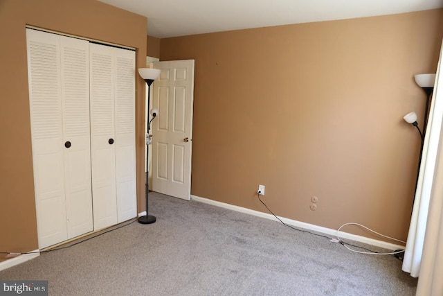 unfurnished bedroom featuring light carpet and a closet