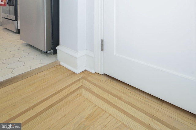 interior details with light hardwood / wood-style flooring and stainless steel range oven