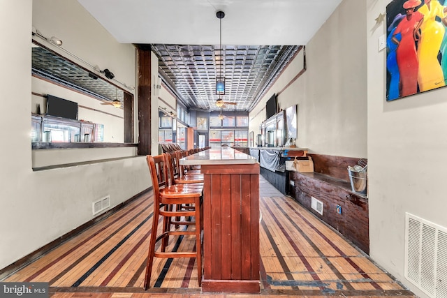 bar with ceiling fan and hanging light fixtures