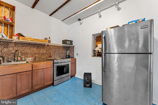 kitchen featuring beam ceiling, sink, rail lighting, stainless steel appliances, and tasteful backsplash