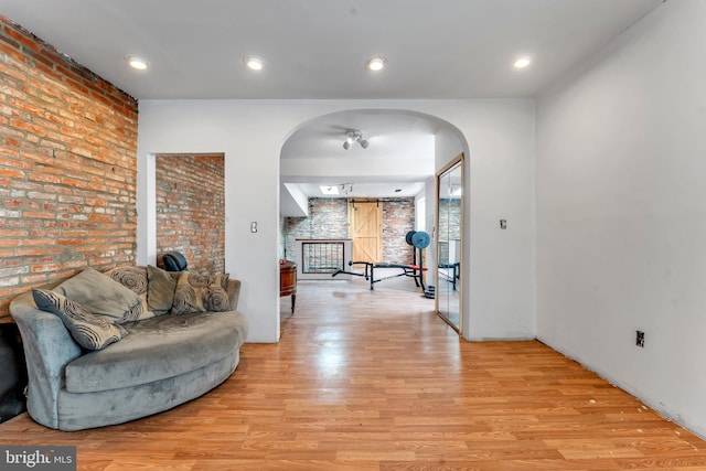 living room featuring light hardwood / wood-style flooring and brick wall