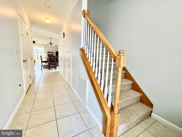 staircase with tile patterned floors and ceiling fan