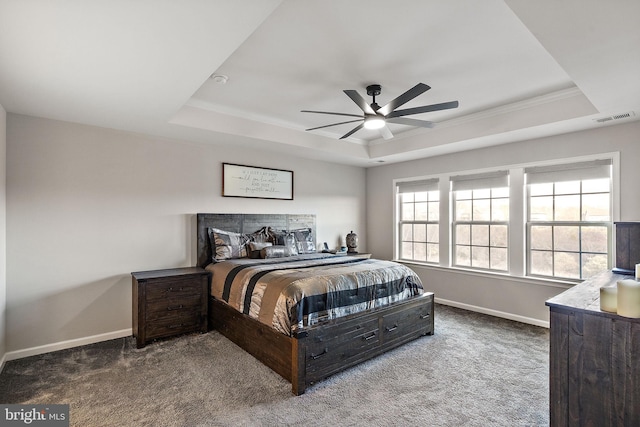 carpeted bedroom with ceiling fan, ornamental molding, and a tray ceiling