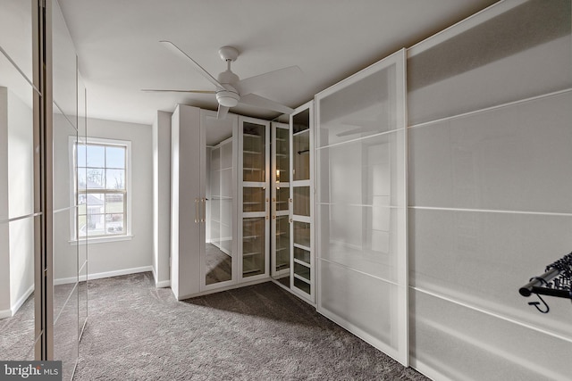 interior space featuring ceiling fan and dark colored carpet