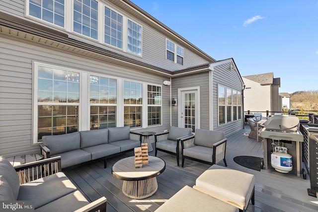 wooden deck with area for grilling and an outdoor hangout area