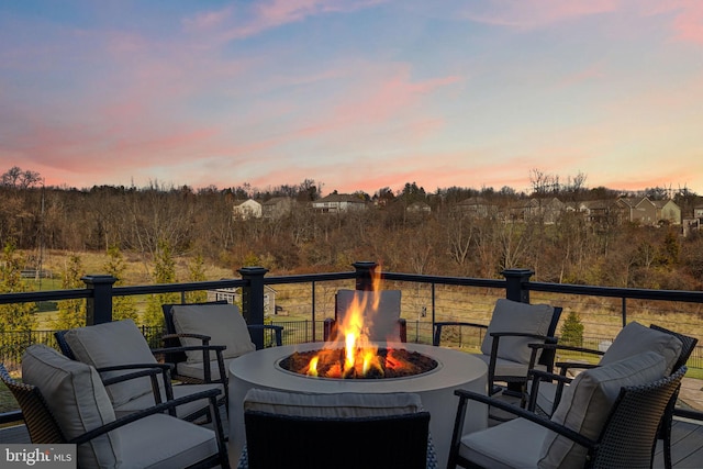 deck at dusk featuring an outdoor fire pit