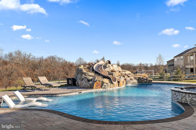 view of swimming pool with a patio area and a water slide