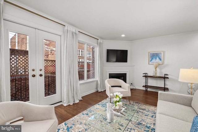 living room with a wealth of natural light, crown molding, and dark wood-type flooring