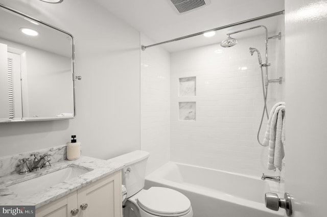 full bathroom featuring tiled shower / bath, vanity, and toilet