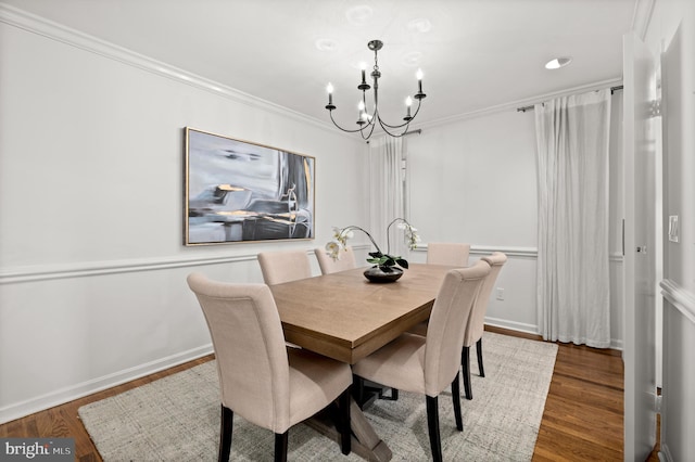 dining room featuring hardwood / wood-style flooring, ornamental molding, and an inviting chandelier