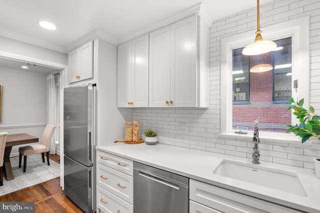 kitchen featuring white cabinets, decorative light fixtures, sink, and stainless steel appliances