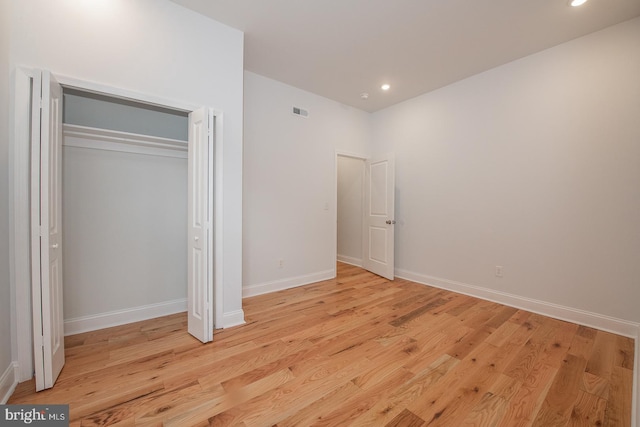 unfurnished bedroom with light hardwood / wood-style flooring and a closet