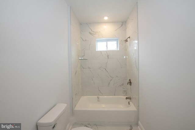 bathroom with tiled shower / bath and toilet