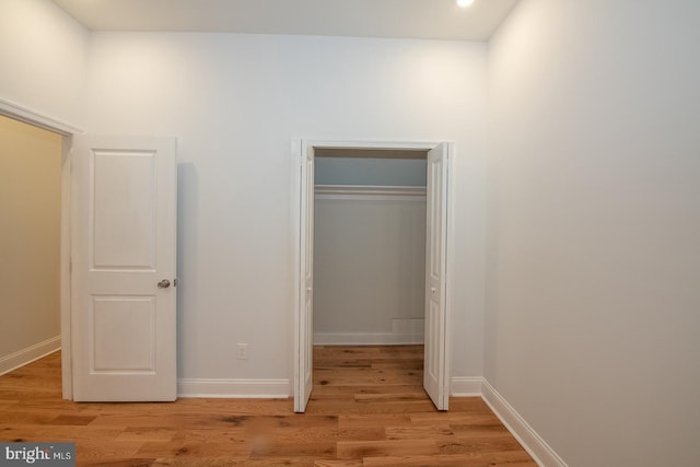 unfurnished bedroom with light wood-type flooring and a closet