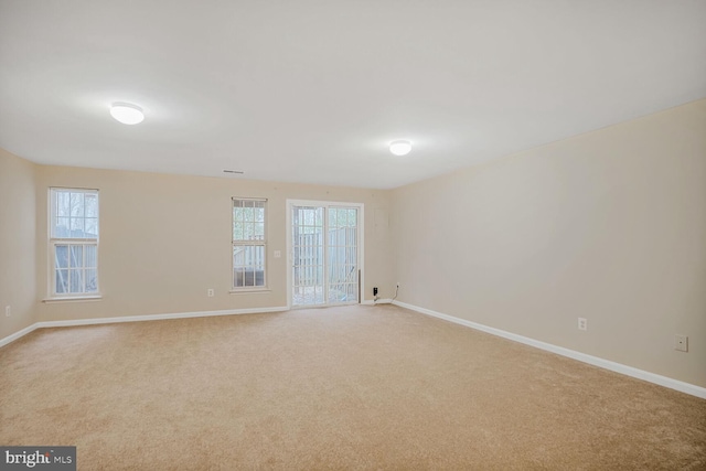 empty room with baseboards and light colored carpet