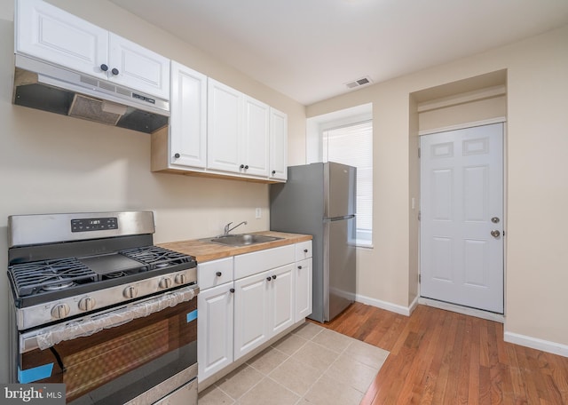 kitchen with sink, light hardwood / wood-style flooring, white cabinets, and appliances with stainless steel finishes