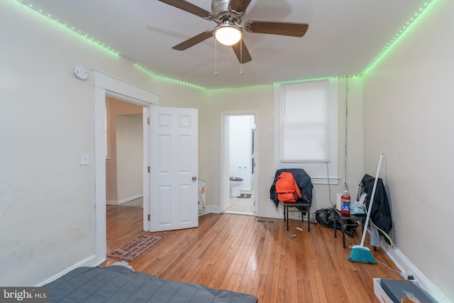 bedroom with ensuite bath, light hardwood / wood-style flooring, and ceiling fan