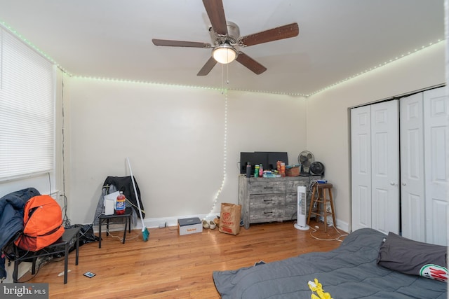 bedroom with ceiling fan, light hardwood / wood-style floors, and a closet