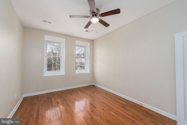 spare room featuring wood-type flooring and ceiling fan