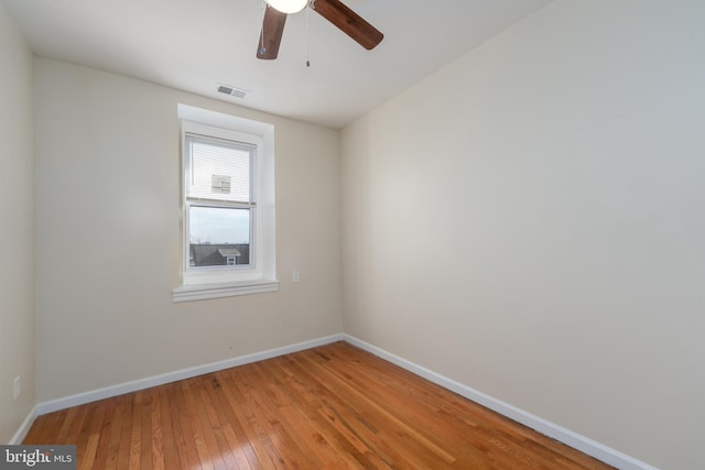 empty room with hardwood / wood-style floors and ceiling fan