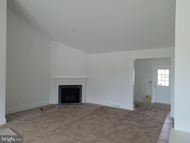 unfurnished living room with a fireplace with flush hearth, visible vents, and baseboards