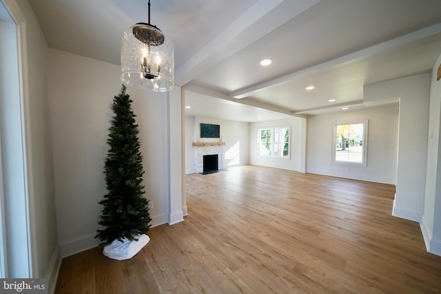 unfurnished living room with light hardwood / wood-style floors and a notable chandelier