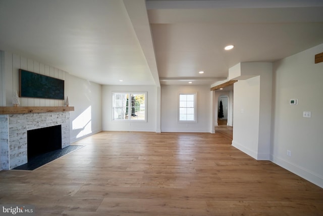 unfurnished living room with light wood-type flooring and a fireplace