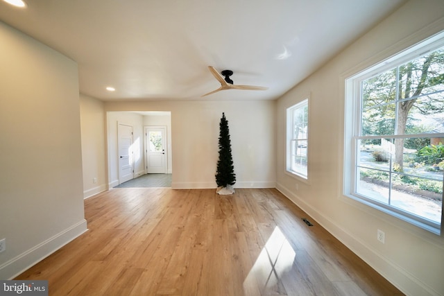 unfurnished living room featuring ceiling fan and light wood-type flooring