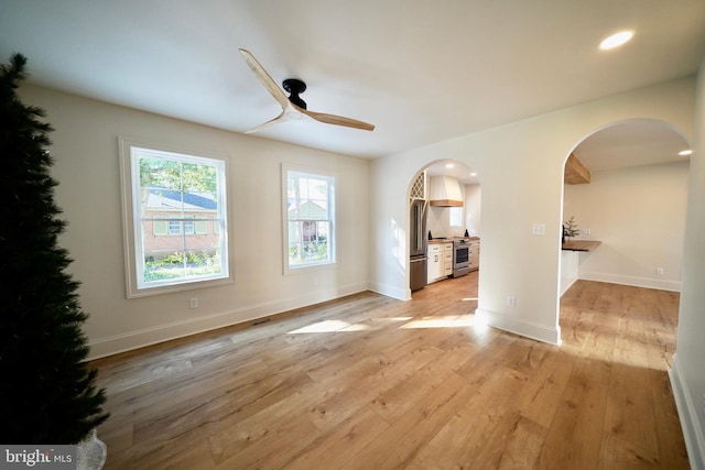 unfurnished living room featuring ceiling fan and light hardwood / wood-style floors