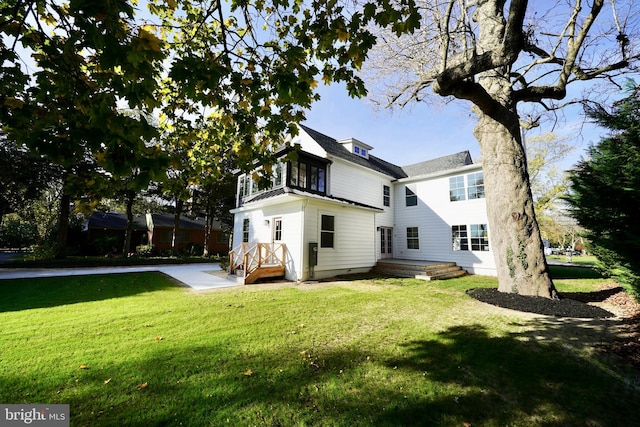 rear view of property featuring a lawn