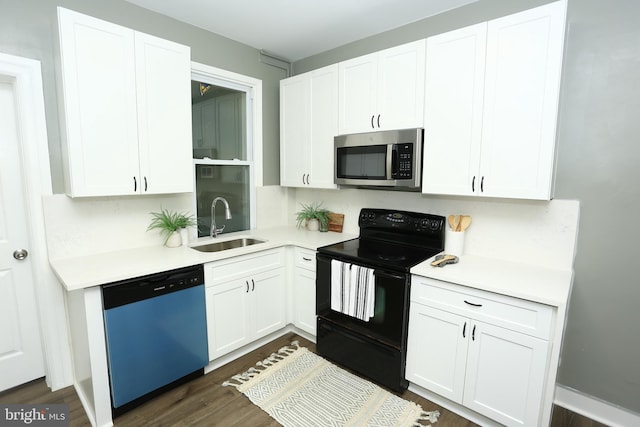 kitchen with dark hardwood / wood-style flooring, white cabinetry, sink, and appliances with stainless steel finishes