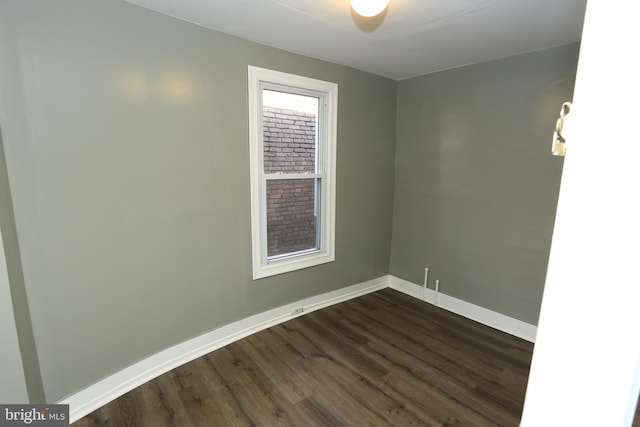 unfurnished room with dark wood-type flooring