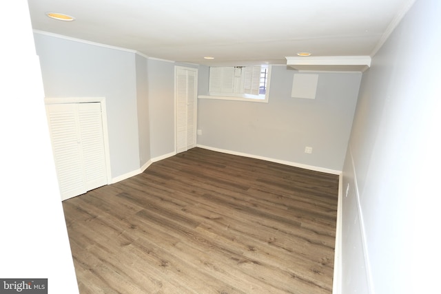 basement with hardwood / wood-style floors and ornamental molding