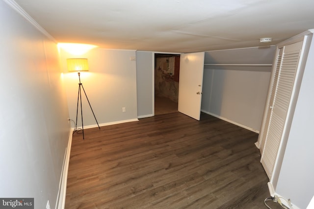 unfurnished bedroom featuring dark hardwood / wood-style flooring, ornamental molding, and a closet